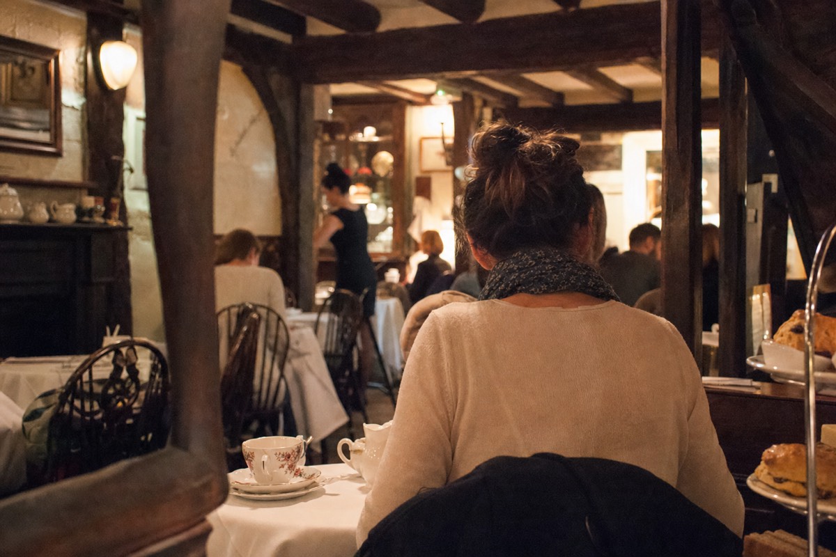 A high-ceilinged tearoom set with white cloths for afternoon tea