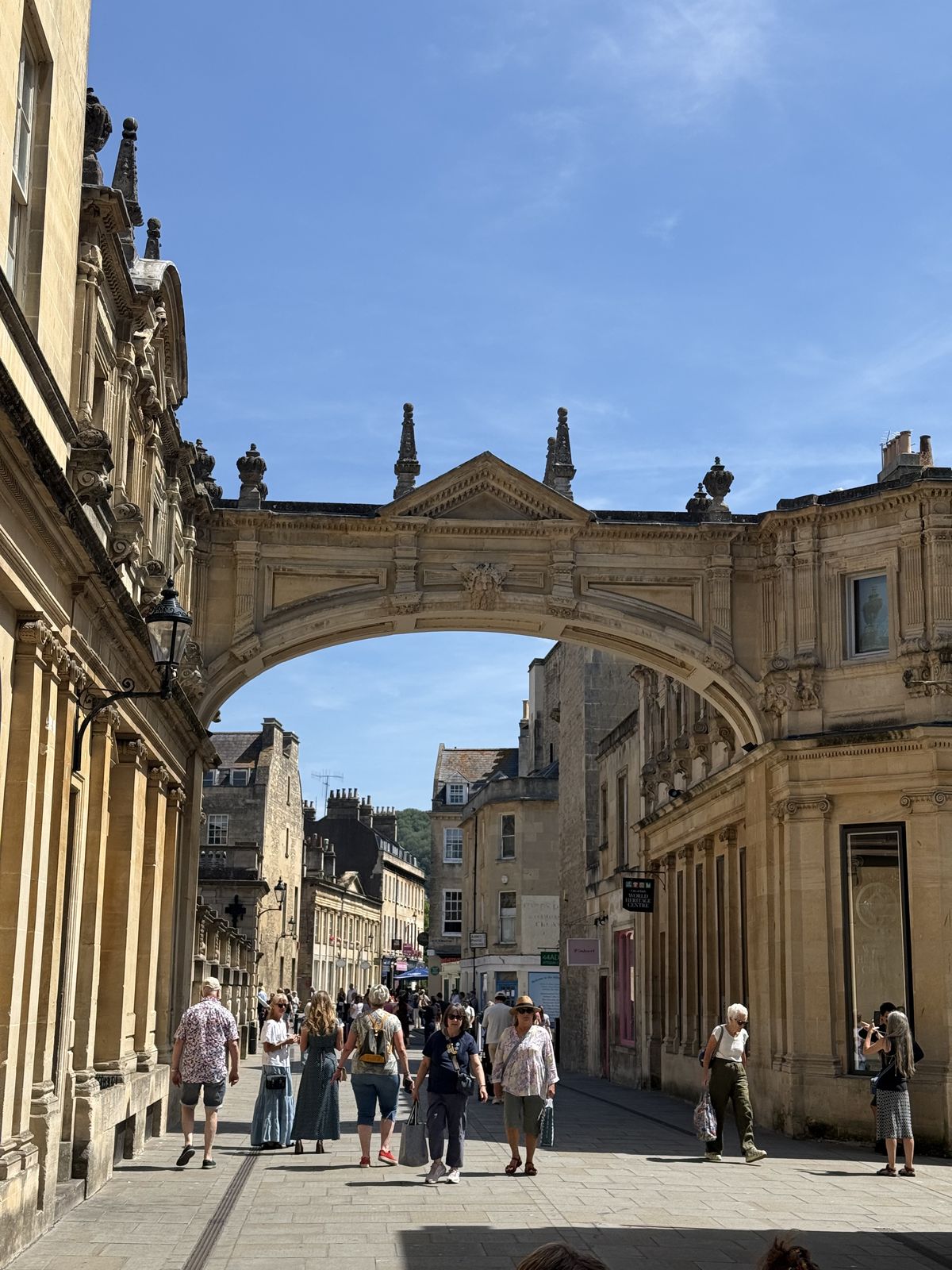 A stone archway framing a quiet Georgian street in Bath