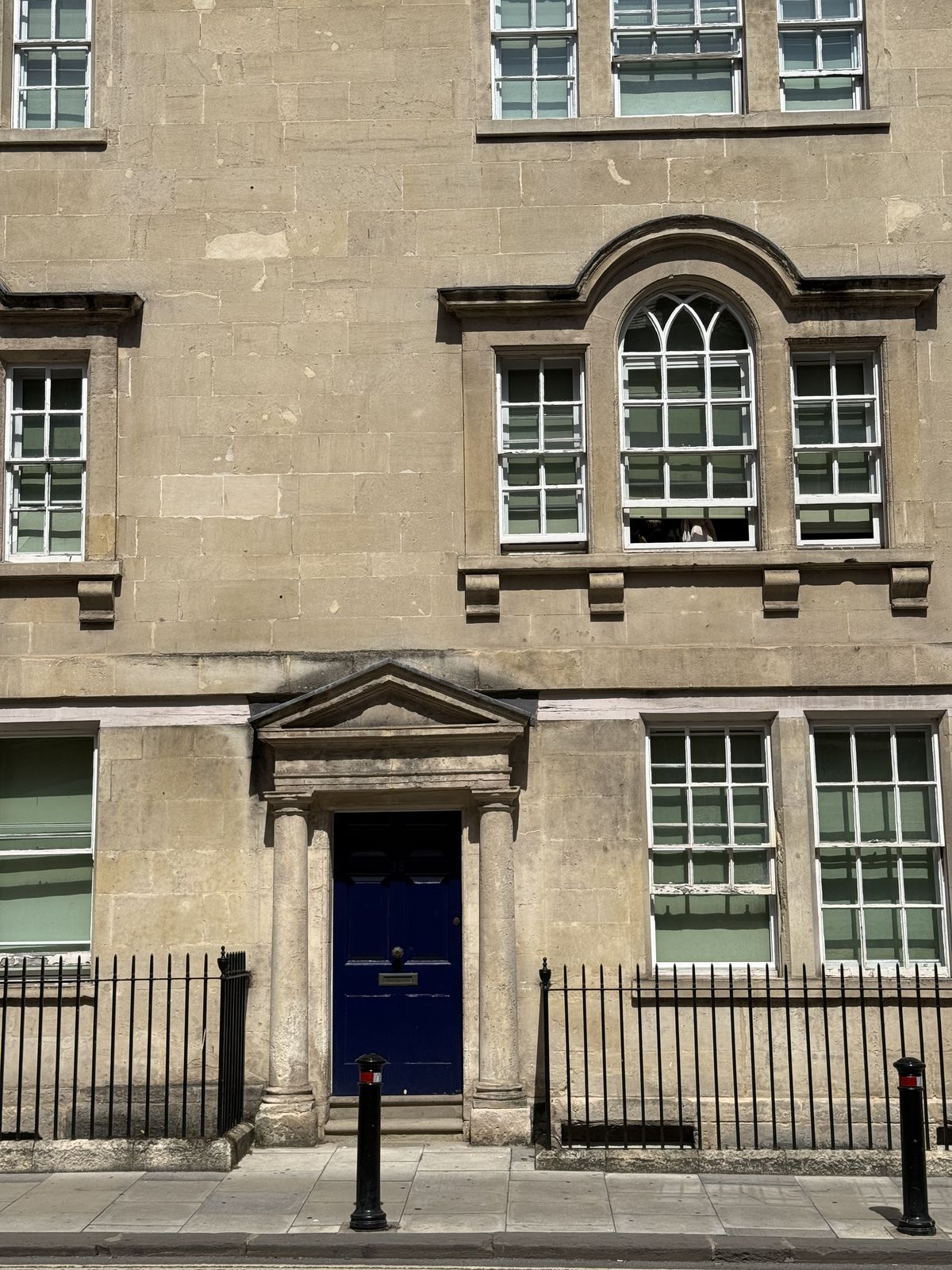a Georgian townhouse in Bath with a blue front door and iron railings