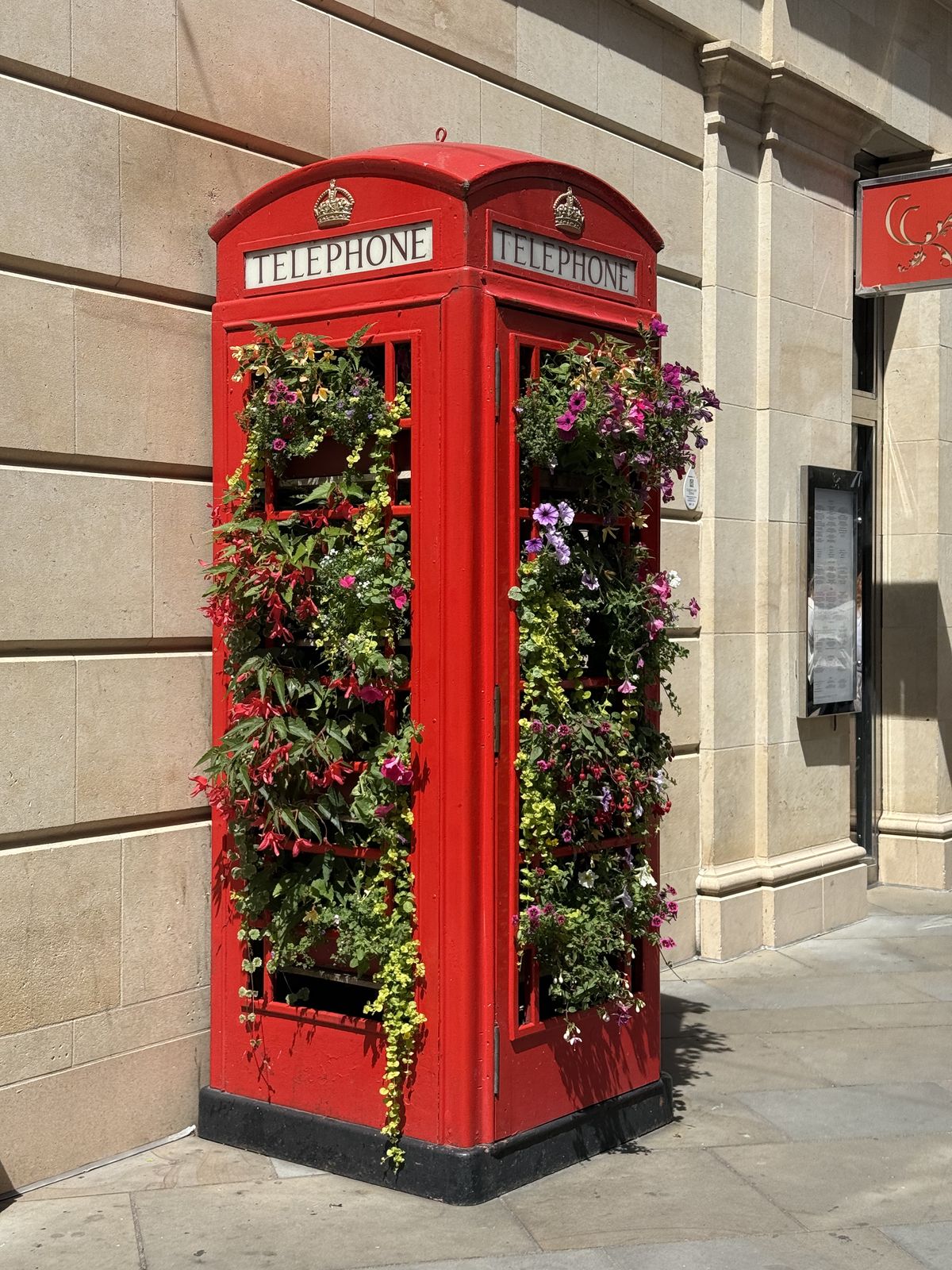 a red telephone box on a quiet street corner in Bath