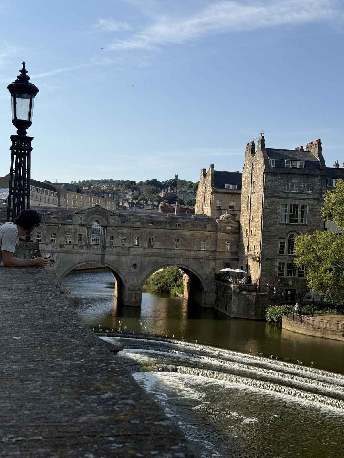 Pulteney Bridge in Bath seen from Grand Parade past an ornate lamp